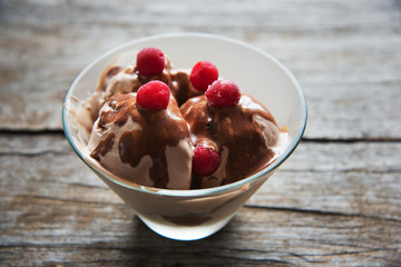 chocolate ice cream with syrup and frozen cherries