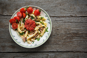 Penne pasta in tomato sauce with chicken, tomatoes decorated  parsley