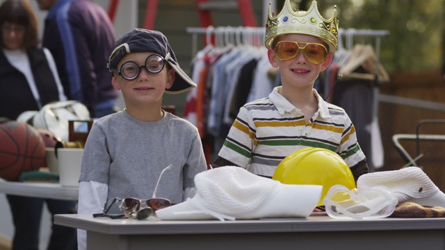 Two boys at garage sale with funny hats and glasses