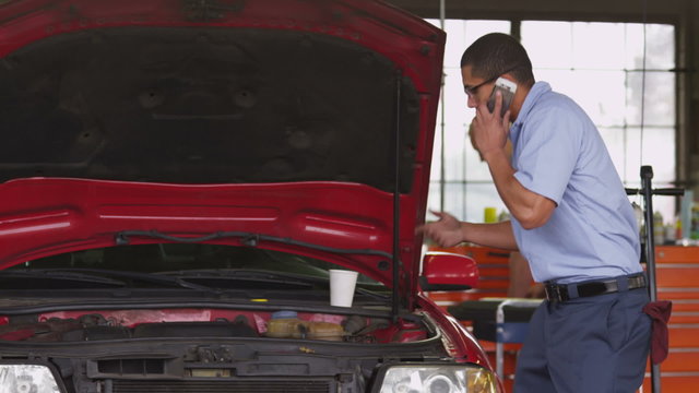 Auto mechanic talking on cell phone