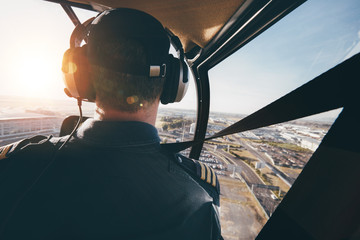 Pilot flying a helicopter over a city