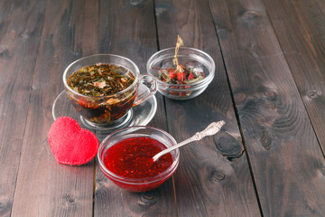 raspberry jam on table with cup of herbal tea