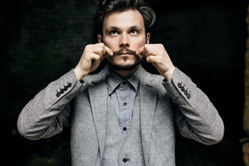 Portrait Elegant bearded
vintage retro young handsome Businessman man hipster and He twists his...