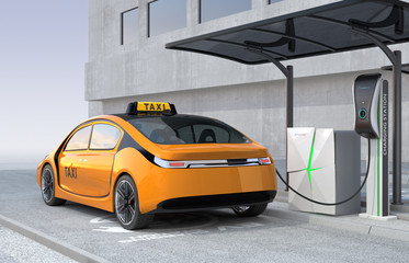 Yellow electric taxi charging in charging station. The charging station supply by solar panel and battery.