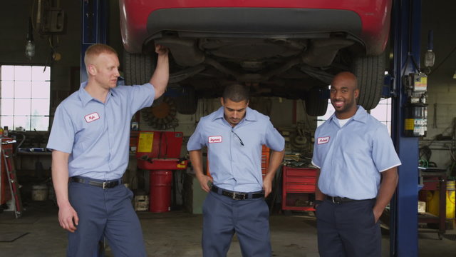 Portrait of three auto mechanics in shop