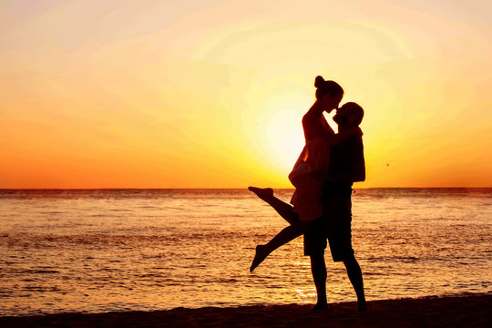 Romantic Couple On The Beach At Colorful Sunset On Background