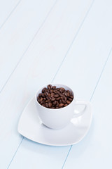 Coffee cup with coffee beans on table