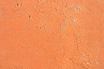 Orange cracked paint on the concrete wall