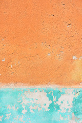 orange and turquoise strip of cracked paint on the concrete wall