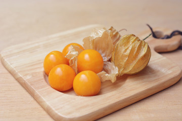 Cape gooseberry (Physalis) on wooden plate