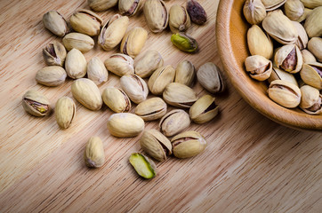 roasted and salted pistachios on wooden background.