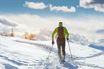 Man in winter landscape with snowshoes