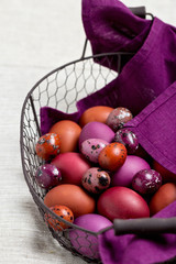 Easter eggs colored in purple and brown in the basket.