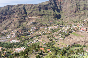 Fototapeta na wymiar Villages and small towns in the Valle Gran Rey on la Gomera. Terraced fields and date palms is a typical landscape for the Valle Gran Rey, the beautiful canyon on the Canary island La Gomera