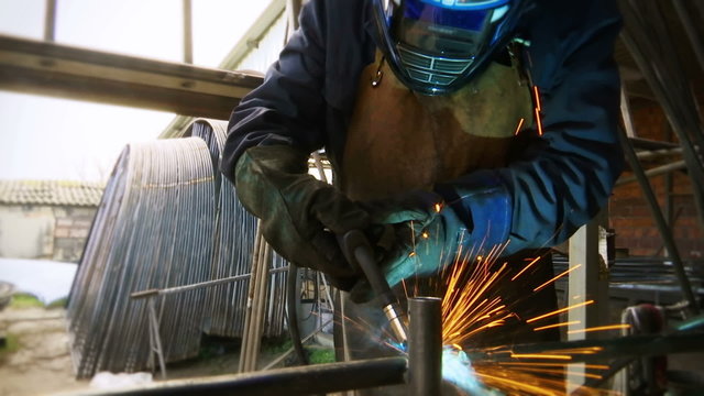 Welder in the workshop performs arc welding