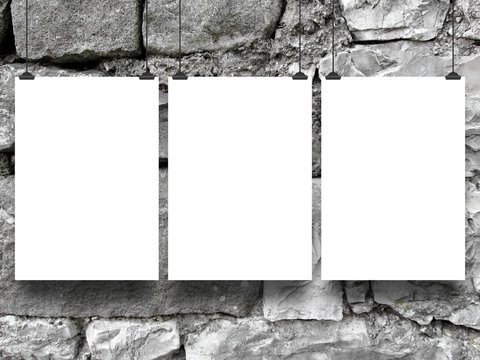 Close-up of three hanged blank frames with clips on grey stone wall background