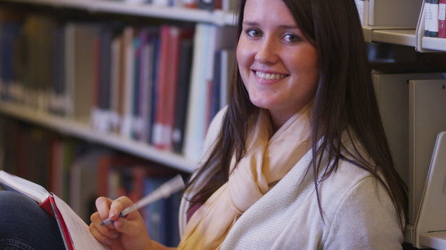 Portrait of college student studying in library