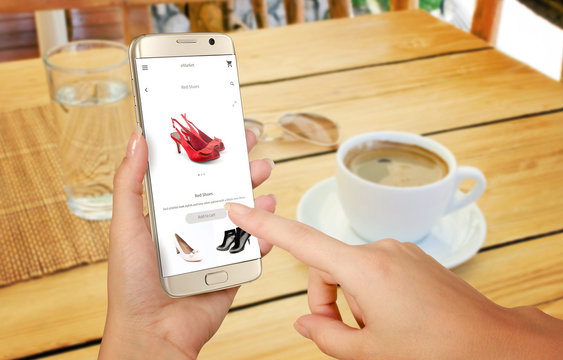 Online shopping with smart phone. Isolated phone in woman hand. Buying women shoes on online store.