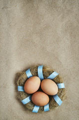 Fototapeta na wymiar Nest wreath with eggs on eco craft paper background