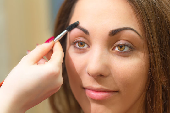 Forming eyebrow with special product and brush.