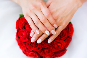 Fototapeta premium Red wedding bouquet of flowers and bride’s hands