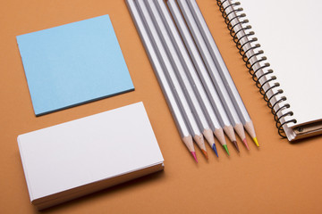 Office desk table with supplies top view. Notepad, pencil and blank business card colorful paper. Copy space for text