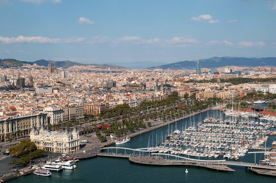  Panoramic view of Port Vell in Barcelona. Sagrada Familia and Torre Agbar are visible in the distance.