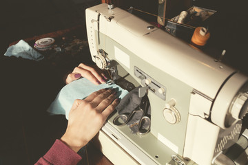 Tailor doing her work on a retro sewing machine.