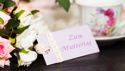 Mothers day deutch congratulation card and roses on wooden board