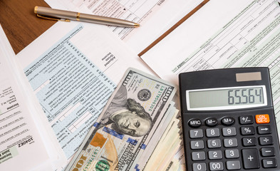 Obraz premium us tax form with dollar and calculator on desk