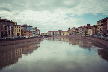 PISA, ITALY - MARCH 10, 2016: River Arno floating through the me