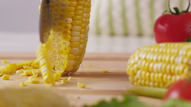 Cutting corn kernels of cob, closeup