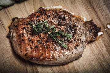 Fresh fried meat with thyme, garlic and cucumber on light wooden