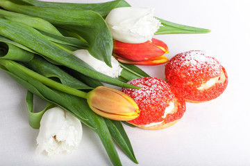 Homemade custard cakes with cream and bunch of spring tulips on