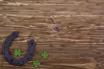 Fabric green clover leaves with horseshoe on wooden background. 