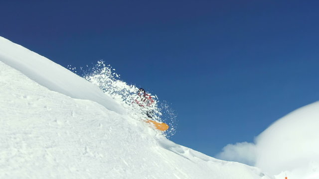 Snowboarder sends snow flying into air, super slow motion