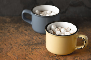 Cups of cocoa with marshmallows on the stone table
