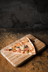 Slice of pizza on the wooden board vertical