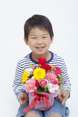 カーネーションの花束を持つ男の子