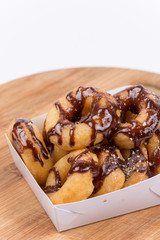 Box with donuts topped with chocolate cream isolated on white