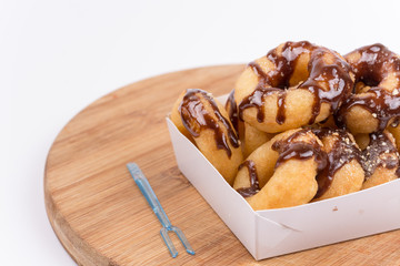 Box with donuts topped with chocolate cream isolated on white