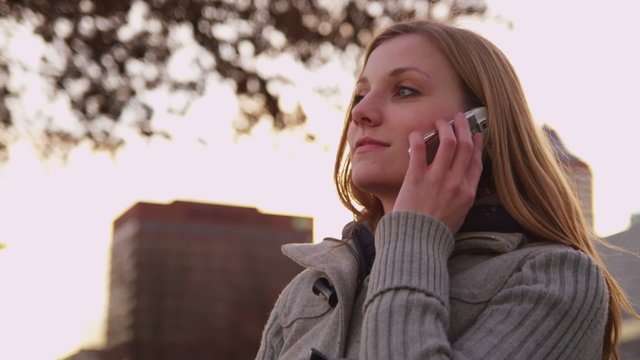 Young woman talking on cell phone in city