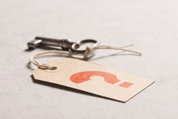 Questionmark on key tag. Symbol of uncertainty, security and access.