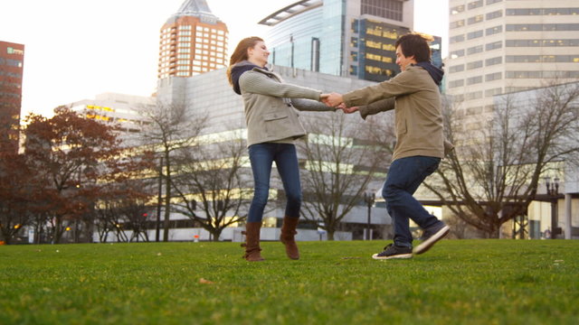 Young couple playing at city park, slow motion