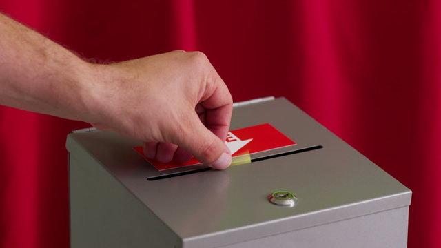 Hand puts vote into ballot box
