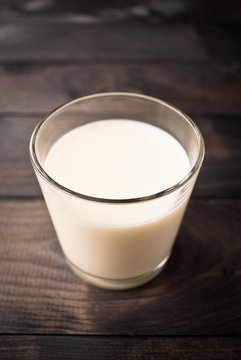 Glass of milk on wooden background