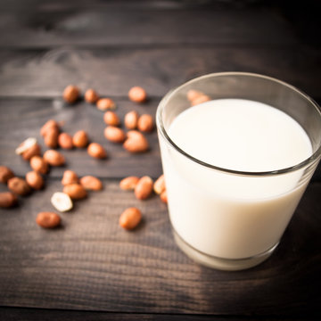 Glass of milk on wooden background