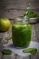 Healthy green smoothie with apple and spinach. Rustic background. Selective focus. Copy space.