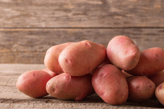 red potatoes on wooden background