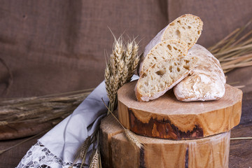 ciabatta with ears of wheat on a white wooden table